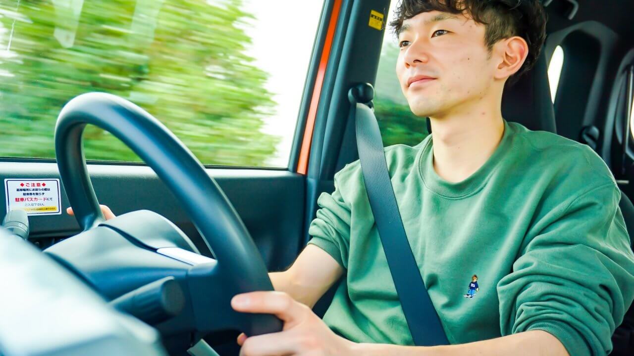 車を運転する若い男性