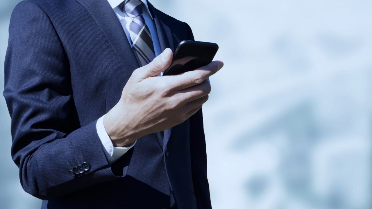 スマホを持つスーツ姿の男性